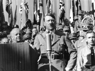 Bundesarchiv_Bild_119-11-19-12,_Adolf_Hitler_bei_Ortsgruppenfeier_der_NSDAP_Rosenheim